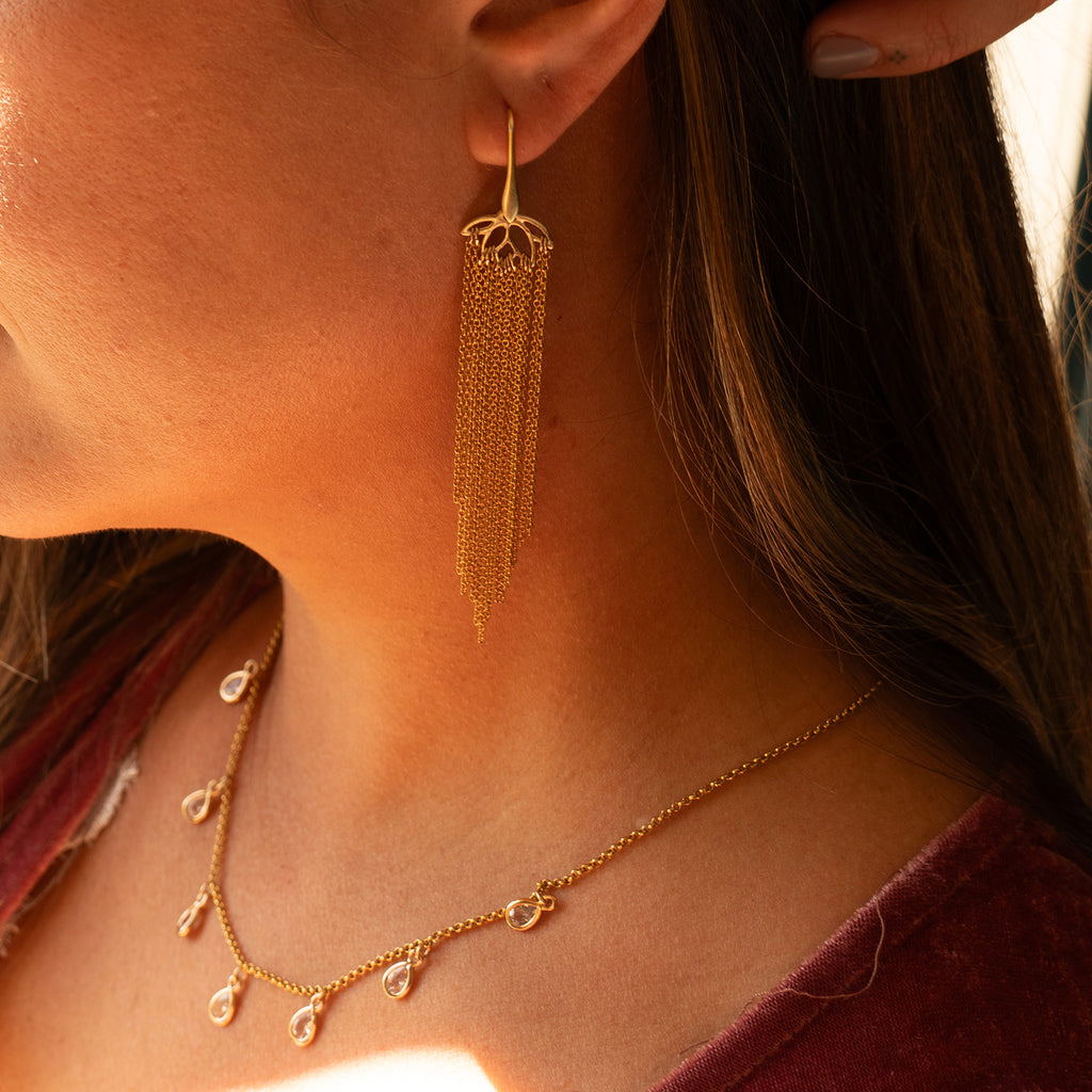 Woman wearing Dew Drop Crystal Necklace and Lotus Fringe Earrings
