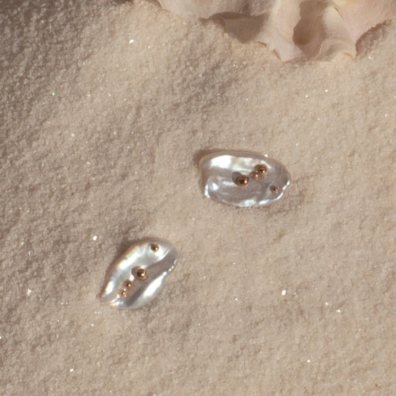 Mini Keshi Pearl Stud Earrings with 14k Solid Gold  on sand