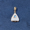 Gold pendant with a rainbow moonstone gemstone on a blue textured background