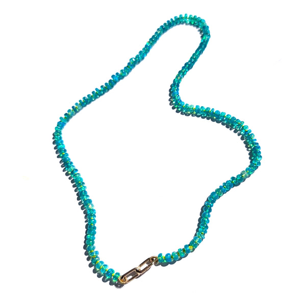 A beaded necklace made of small faceted tblue opal beads with a gold clasp, displayed on a plain white background.