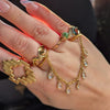 multiple gold rings on a manicured hand. featuring a gold ring connects by chains