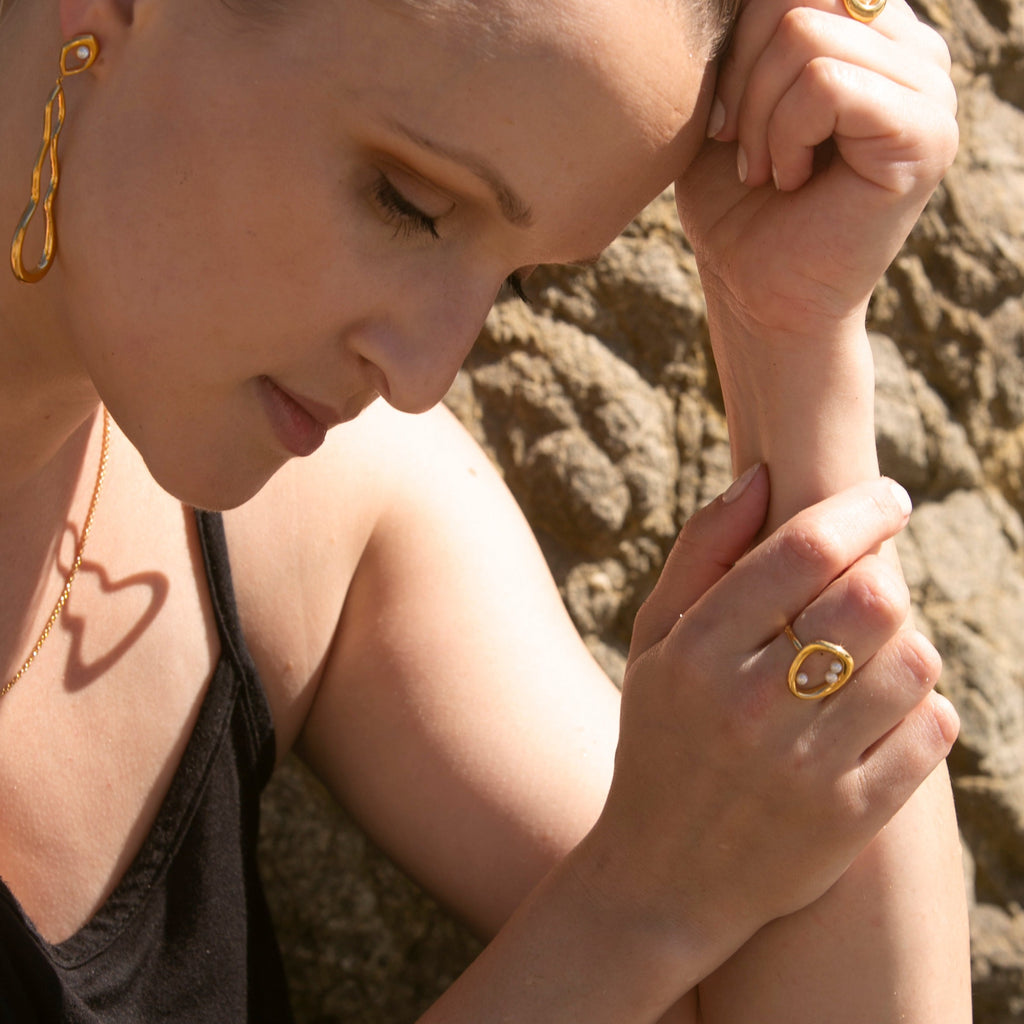 Woman wearing Gold and Pearl Naiad Earrings and Naiad Ring