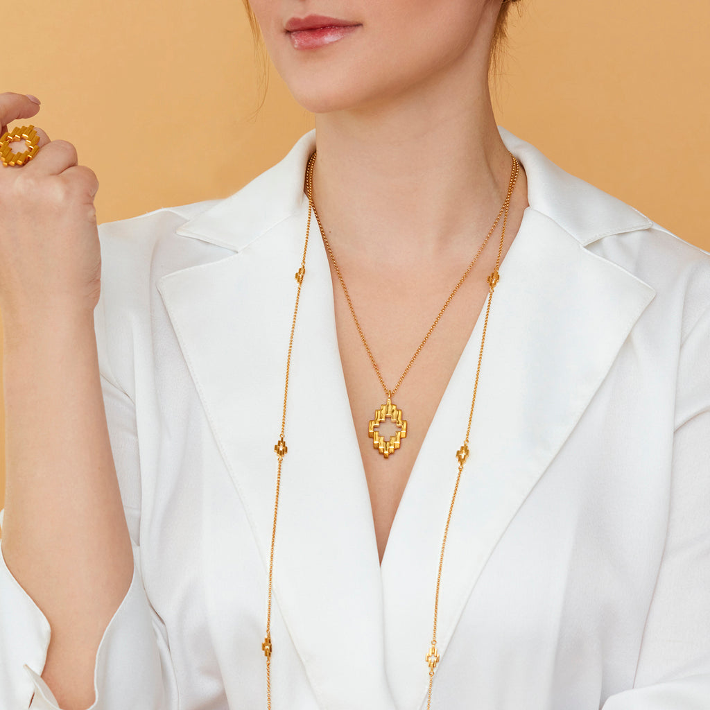 Woman wearing Gold Aura Pendant, Gold Aura Ring, and Gold Aura Station Necklace with a white collard shirt