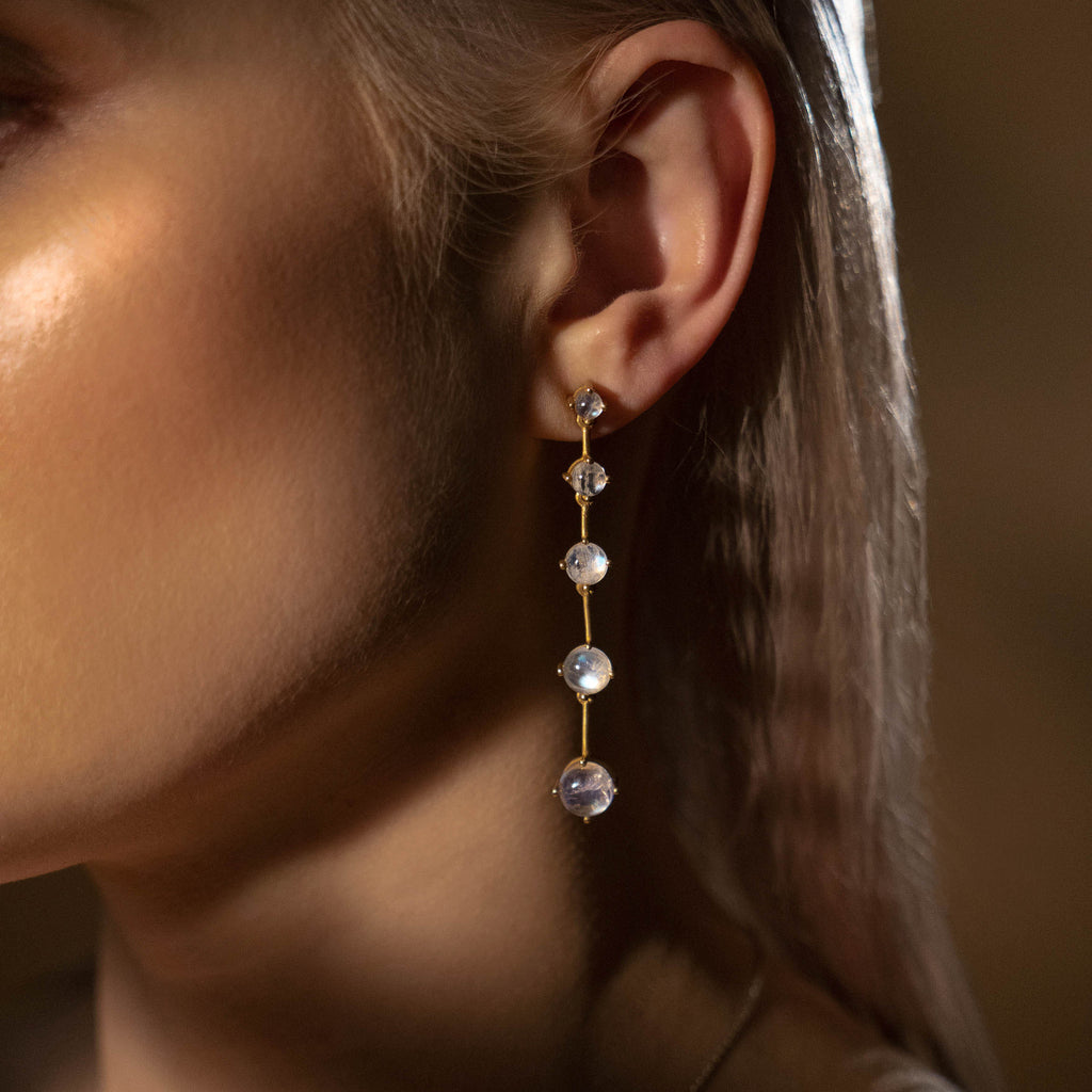Close up of woman wearing the gold and moonstone Astraea Drop Earrings