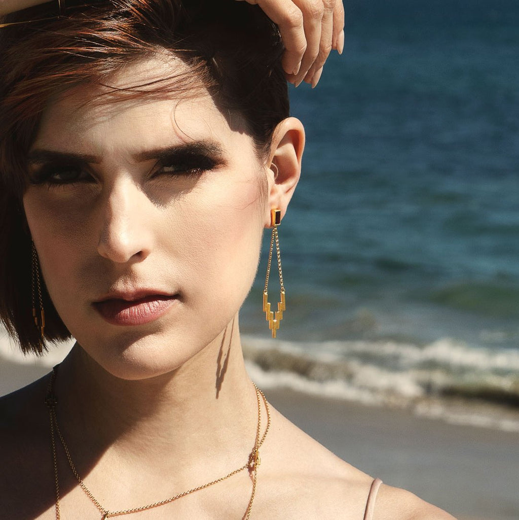 Woman on beach wearing the Amethyst After Glow Earrings