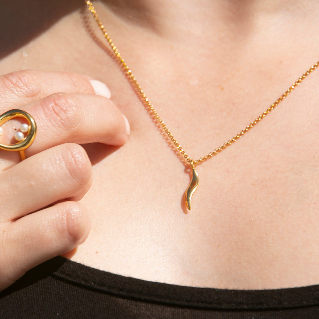 Close up of person wearing Ebb Pendant and Naiad Ring
