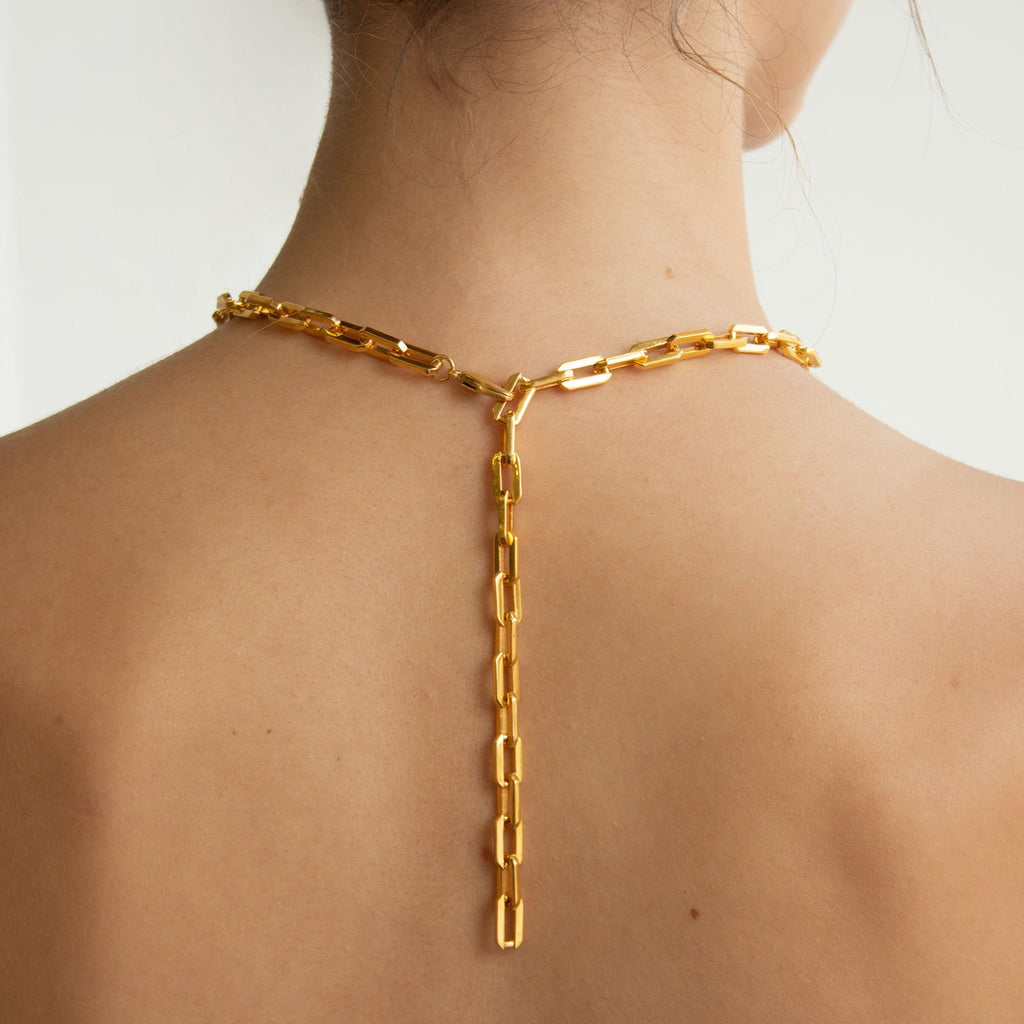 back view of woman wearing a gold Sol Link Necklace at a shorter length