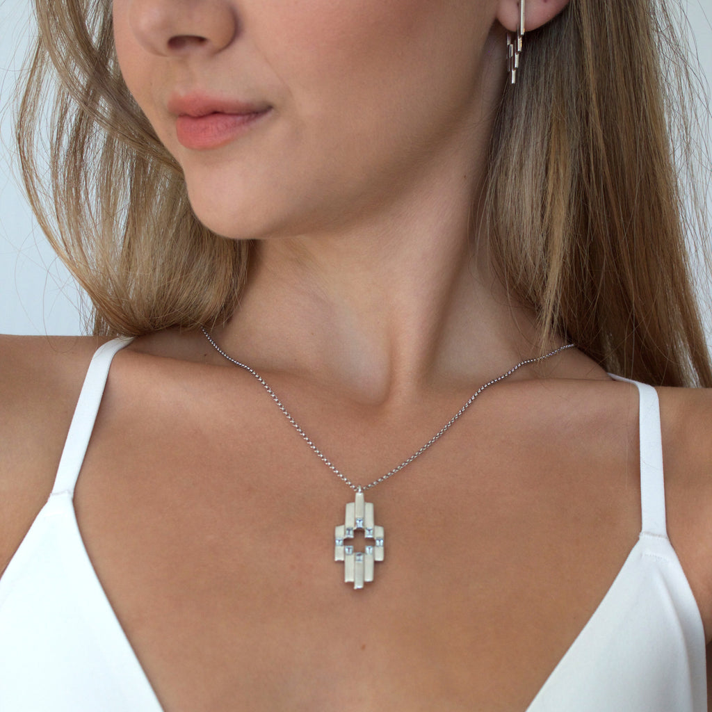Woman wearing Silver Aurora Pendant Necklace with Swiss Blue Topaz and Silver After Gloe Huggies
