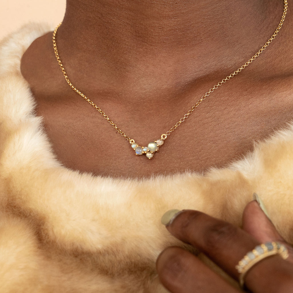 Woman in golden fur wearing Via Lactea Pendant in gold and labradorite