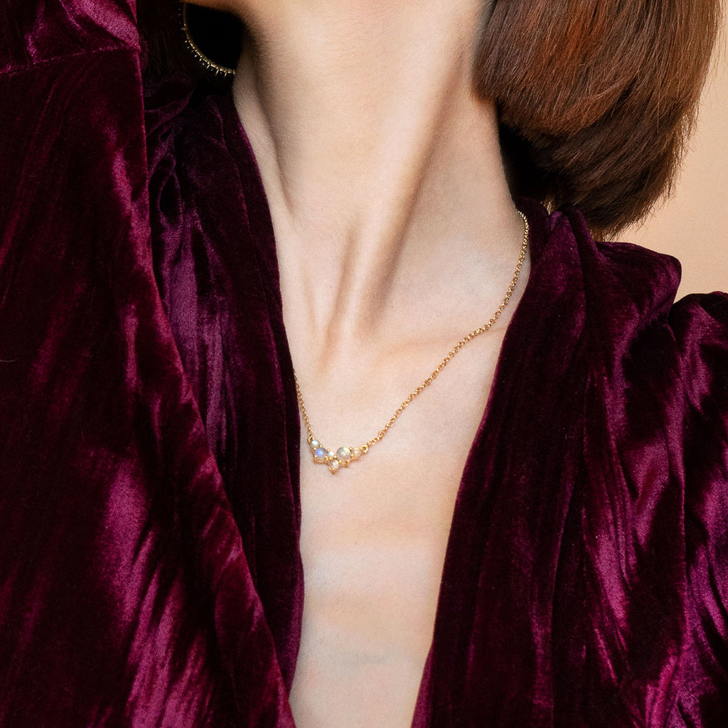 Woman in purple velvet wearing Via Lactea Pendant in gold and labradorite